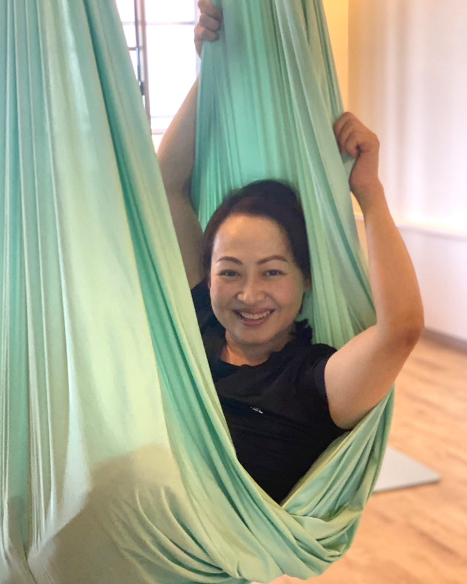 ハンモックの布にくるまれて笑顔を見せる様子